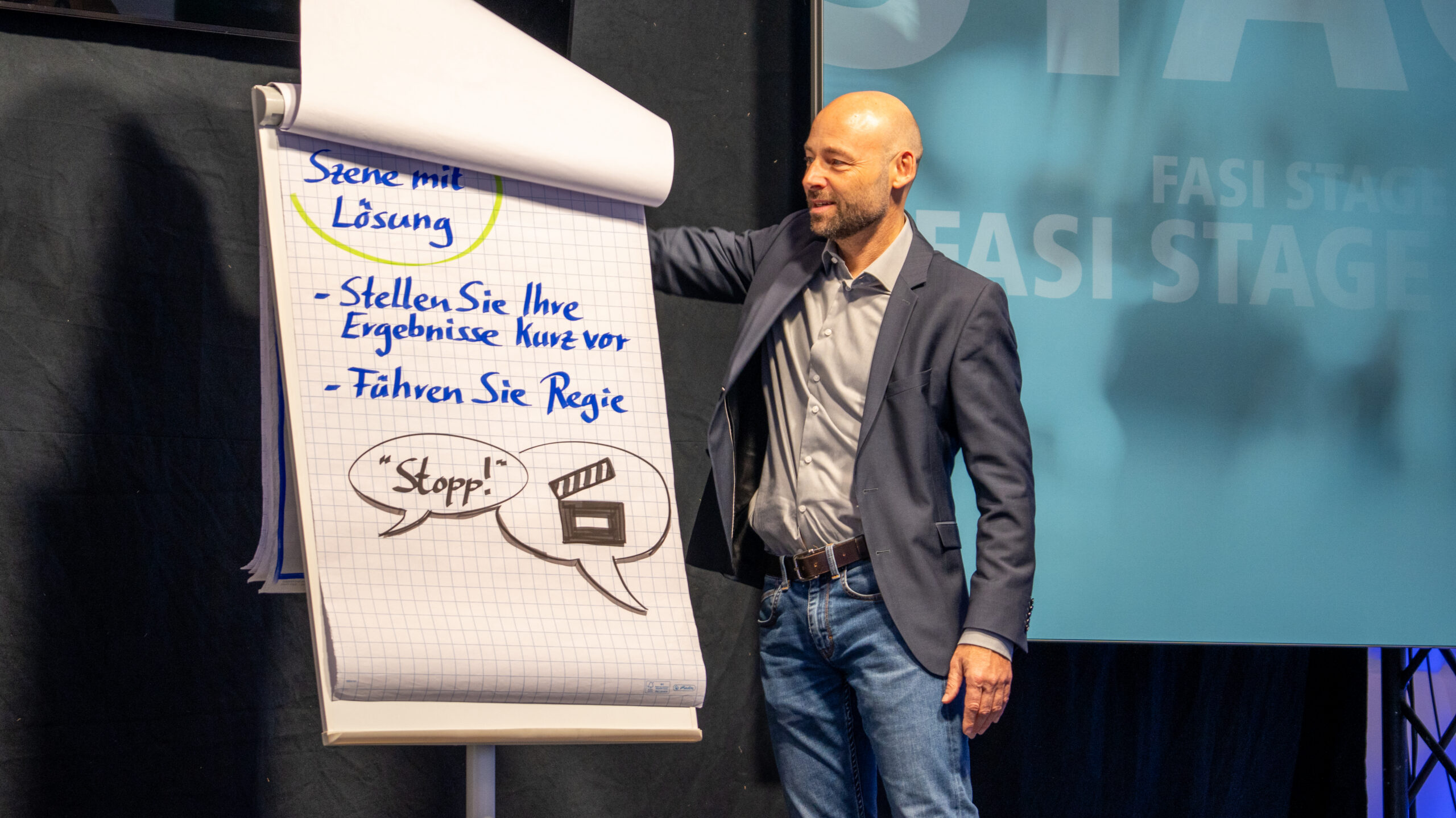 Jörg Ritscher am Flipchart: Szene mit Lösung Jörg Ritscher neben einem Flipchart mit der Überschrift „Szene mit Lösung“ bei einer interaktiven Veranstaltung.